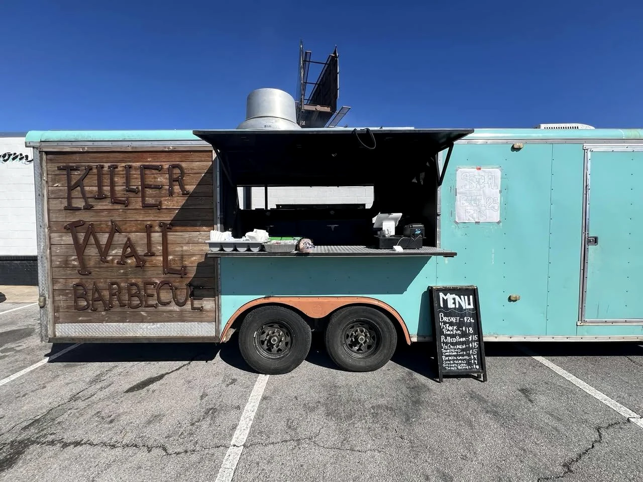 The turquoise Killer Wail Barbecue trailer open for service